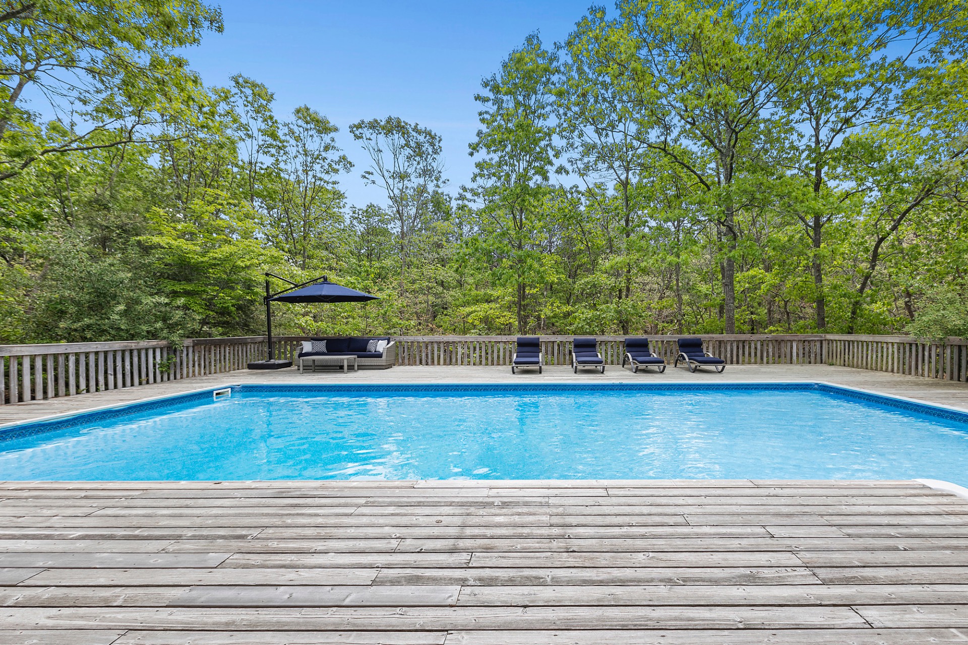 219 Town Line Road Wainscott, NY 11975 - Photo 16 of 19 a view of a swimming pool with trees in the background