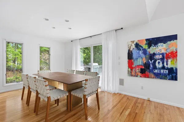 a view of a dining room with furniture a chandelier and wooden floor
