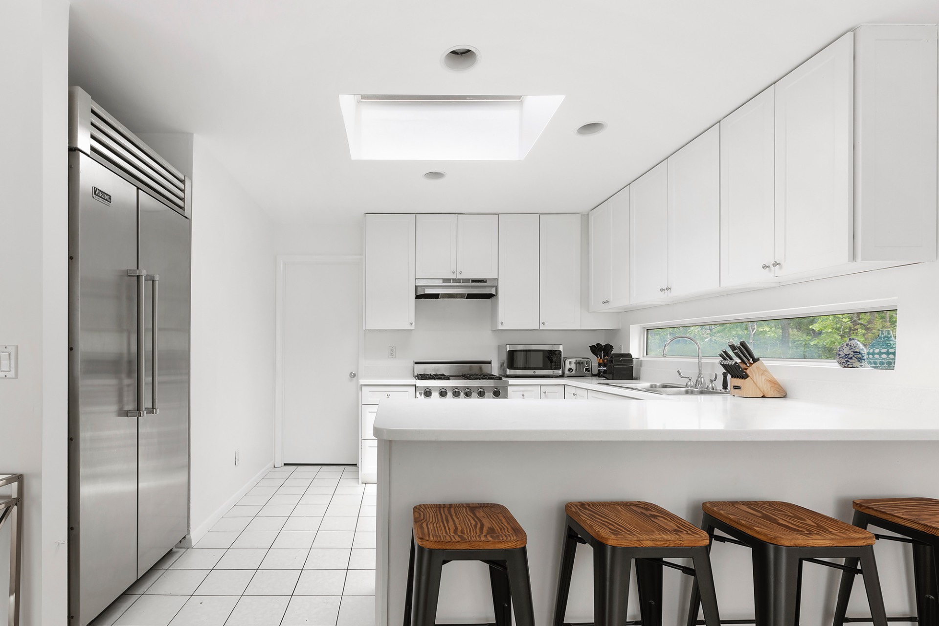 219 Town Line Road Wainscott, NY 11975 - Photo 5 of 19 a kitchen with stainless steel appliances granite countertop a refrigerator a sink a stove and white cabinets