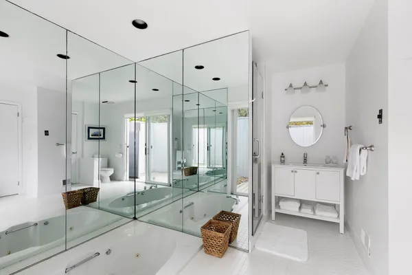 a spacious bathroom with a tub shower and mirror