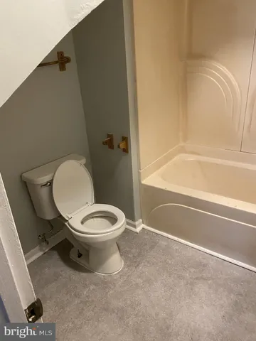 a white toilet sitting next to a bath tub