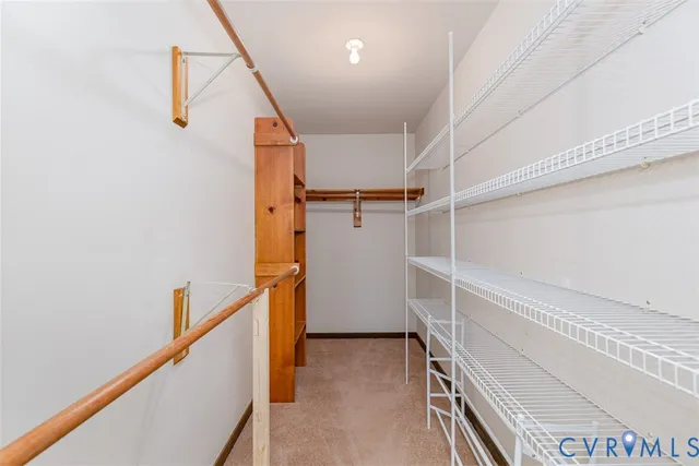 a view of an empty room with wooden floor and furniture