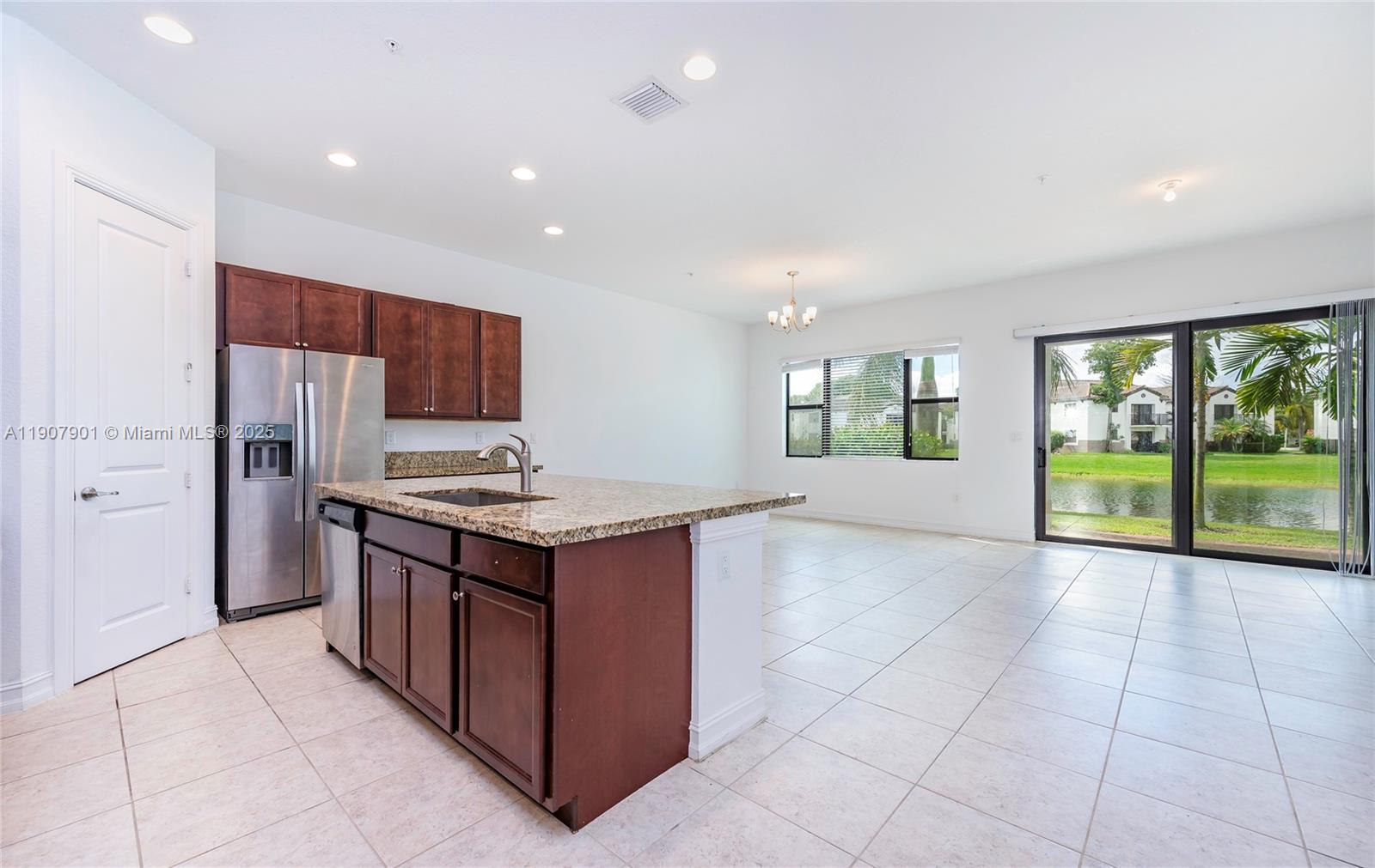 11670 Southwest 13th Lane, Unit 11670 Pembroke Pines, FL 33025 - Photo 13 of 38 a kitchen with kitchen island granite countertop a stove and a sink