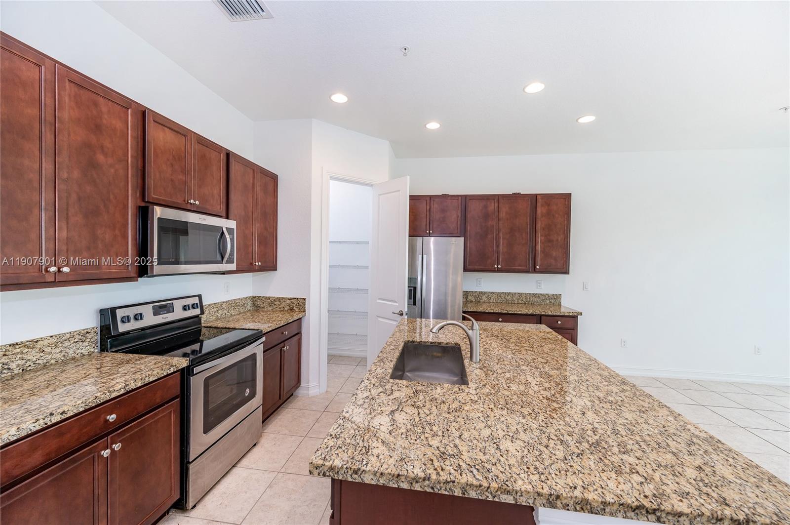 11670 Southwest 13th Lane, Unit 11670 Pembroke Pines, FL 33025 - Photo 19 of 38 a kitchen with stainless steel appliances granite countertop a stove top oven a sink and a granite counter tops