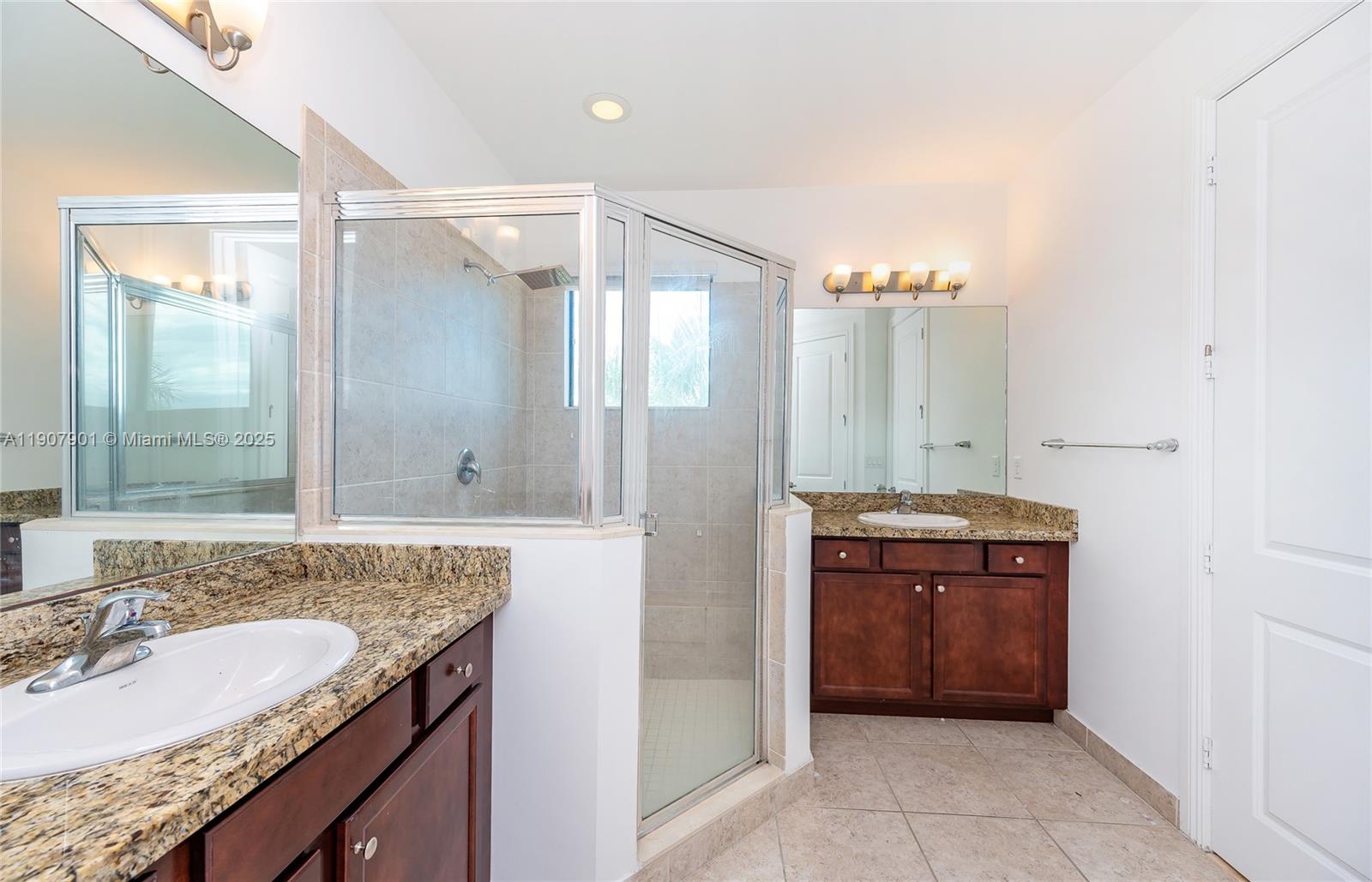 11670 Southwest 13th Lane, Unit 11670 Pembroke Pines, FL 33025 - Photo 26 of 38 a bathroom with a granite countertop sink a mirror and a shower