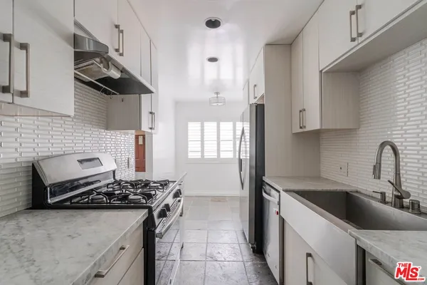 a kitchen with granite countertop a stove and a white cabinet