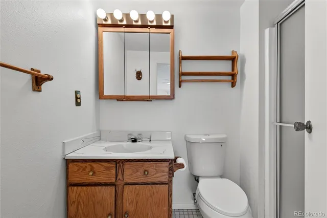 a bathroom with a toilet a sink and mirror