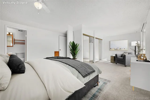 a bedroom with bed large window and couch