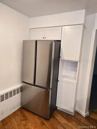 a view of a refrigerator in kitchen and an empty room