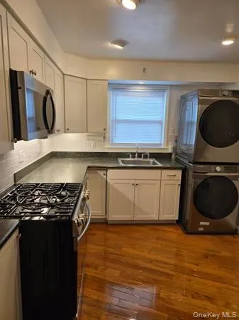 a kitchen with stainless steel appliances granite countertop a stove a sink and a microwave