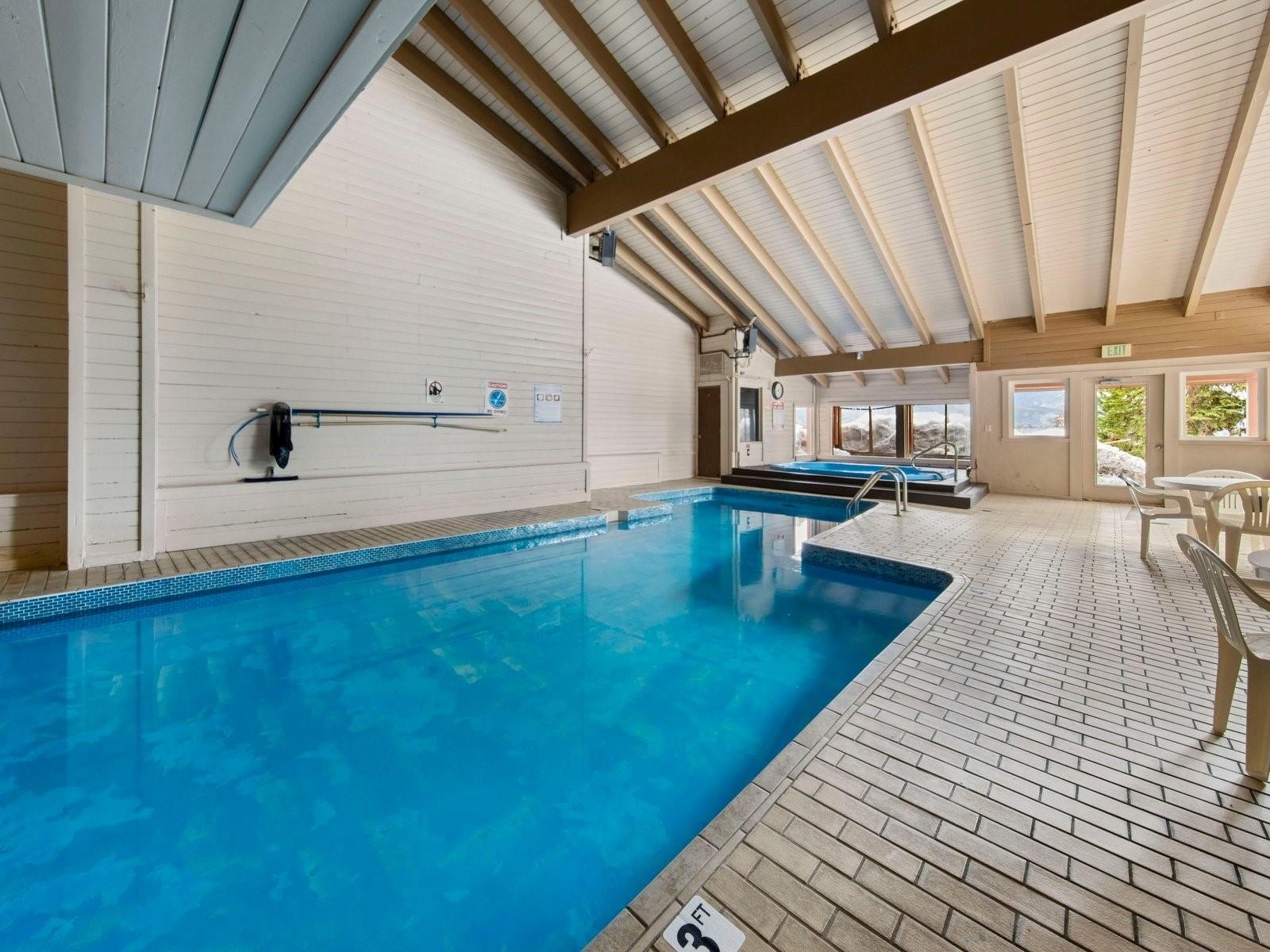 9849 Ryan Gulch Road, Unit 203 Silverthorne, CO 80498 - Photo 35 of 35 Indoor pool featuring a hot tub and a patio