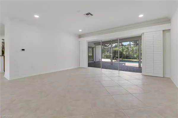 a view of an empty room with glass door and garden