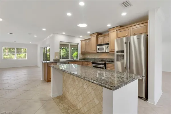 a kitchen with stainless steel appliances granite countertop a sink a stove and a refrigerator