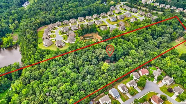 an aerial view of residential houses with outdoor space and trees