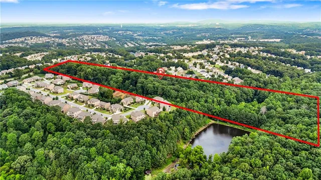 an aerial view of a houses with a yard and lake view
