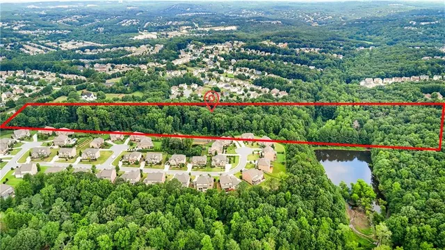 an aerial view of residential houses with outdoor space and trees
