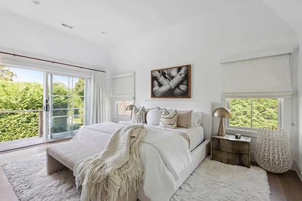 a bedroom with a bed and a large window