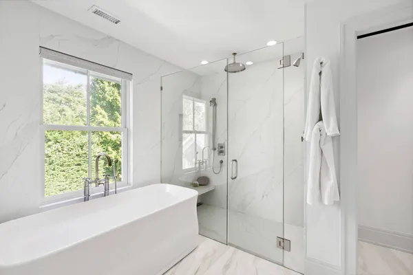 a bathroom with a bathtub shower and a shower