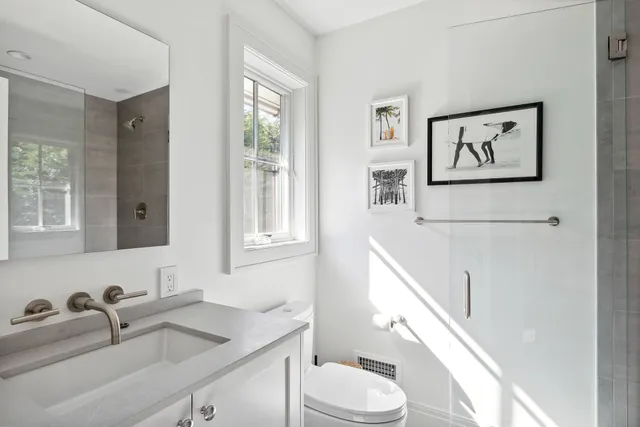 a bathroom with a sink a toilet and a window