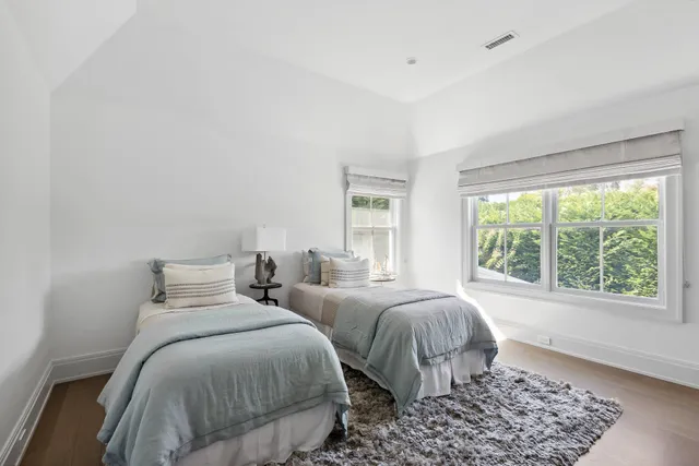 a bedroom with two beds and a window
