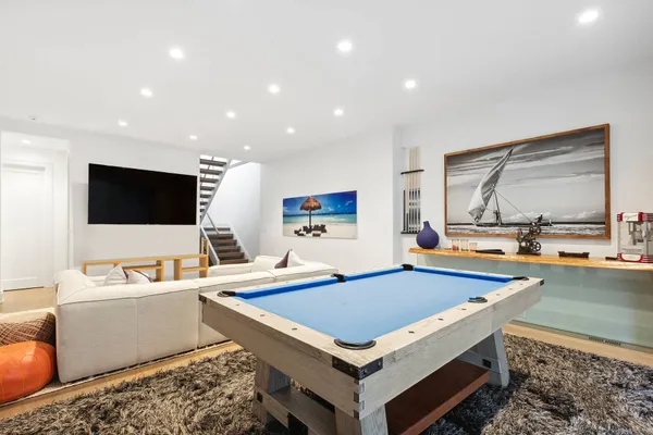 a living room with flat screen tv and pool table