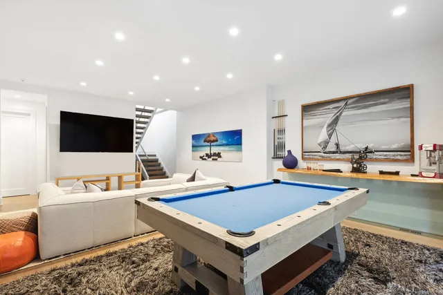 a living room with flat screen tv and pool table