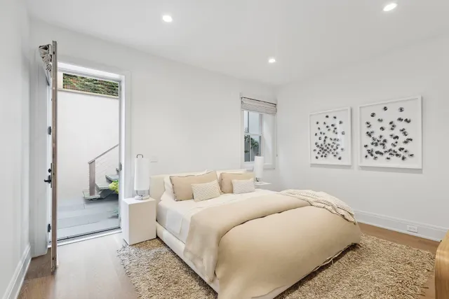 a bedroom with a large bed and a painting on the wall
