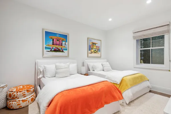 a bedroom with two beds and a large window