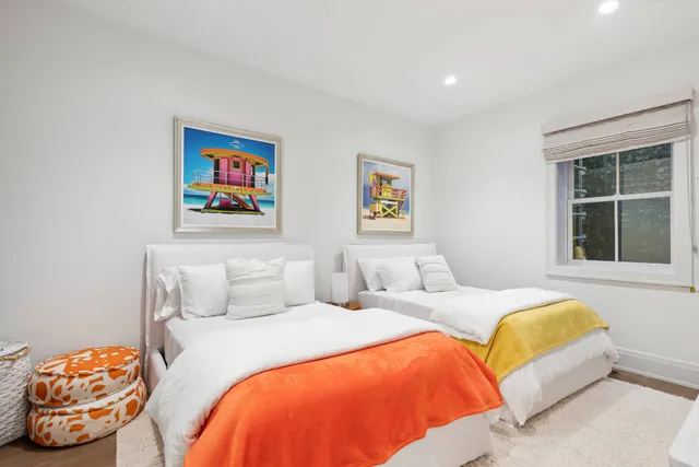 a bedroom with two beds and a large window