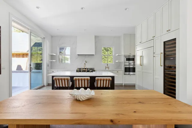 a kitchen with kitchen island a stove a refrigerator a sink dishwasher with a dining table and chairs