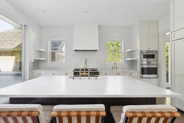 a kitchen with a sink a stove and chairs