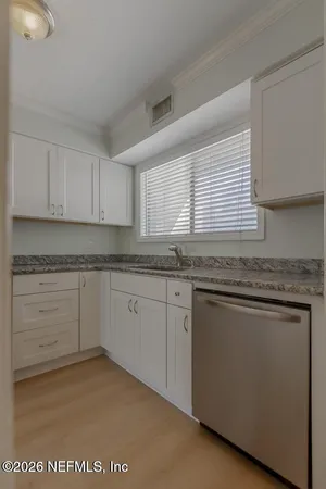 a kitchen with granite countertop cabinets sink and window