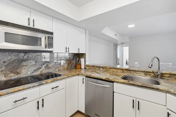 a kitchen with sink cabinets and stainless steel appliances