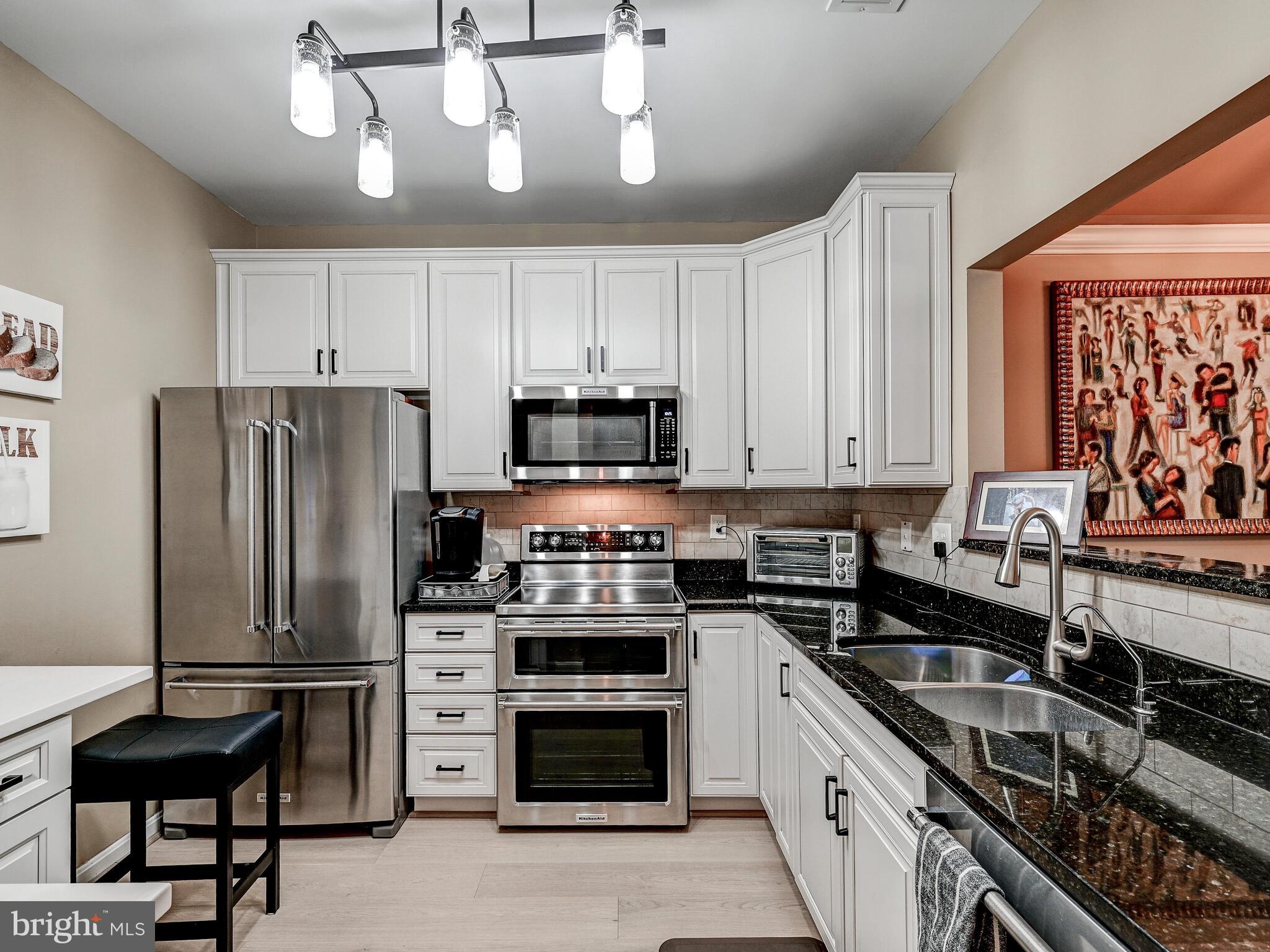 a kitchen with stainless steel appliances a stove a sink and cabinets