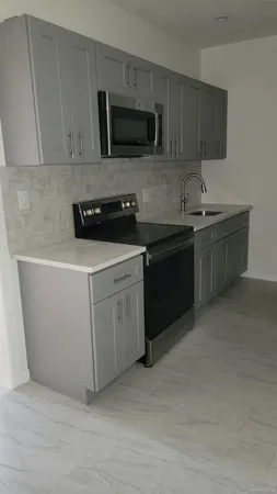 a kitchen with stainless steel appliances granite countertop a stove a sink and a microwave