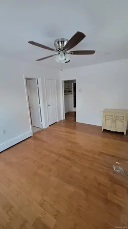 a view of an empty room with a ceiling fan and a window