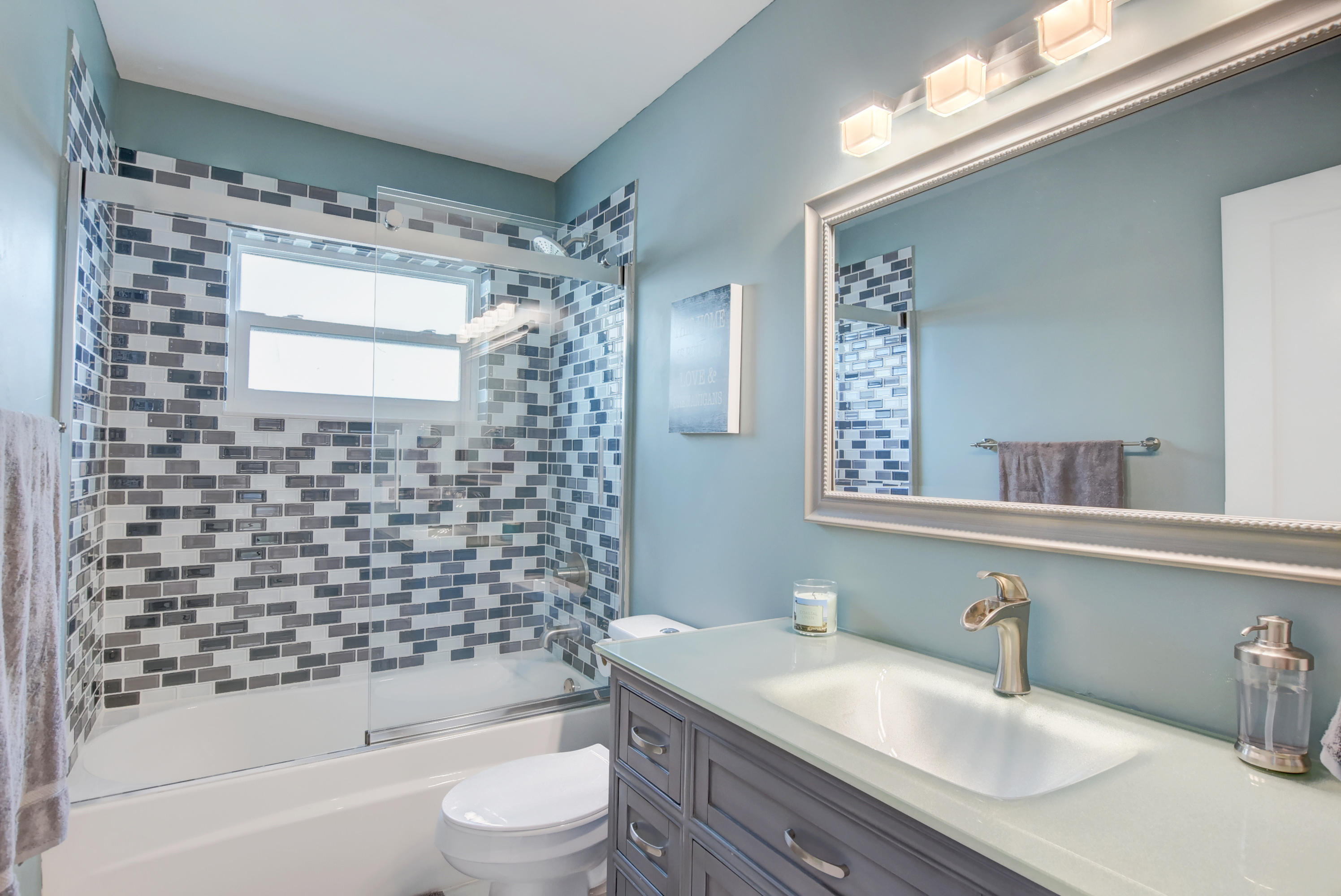 7445 Texas Trail Boca Raton, FL 33487 - Photo 16 of 28 a bathroom with a granite countertop sink toilet a mirror a bathtub and shower