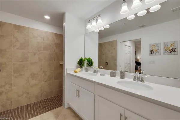 a bathroom with a sink a large mirror and a shower