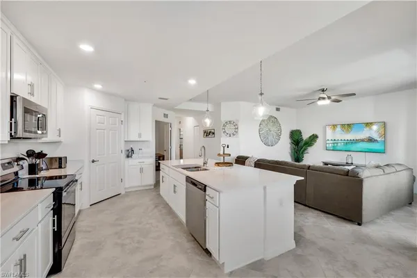 a large kitchen with stainless steel appliances a stove a sink a oven and a refrigerator