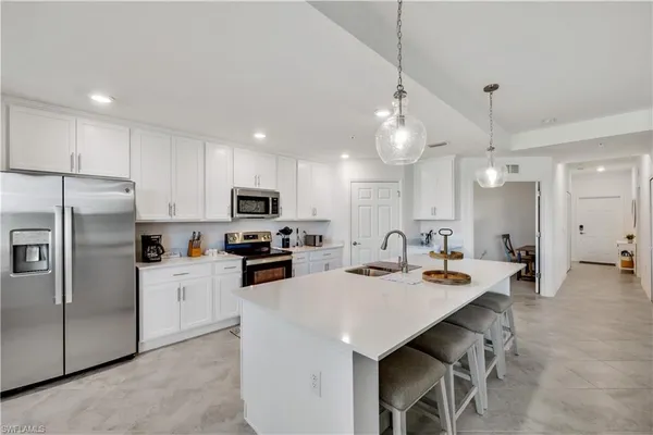 a kitchen that has a lot of cabinets a sink and appliances