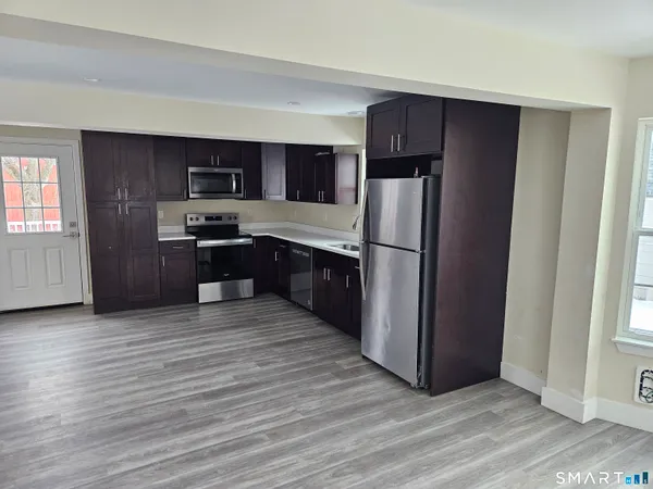 a kitchen with stainless steel appliances granite countertop a refrigerator and a stove top oven