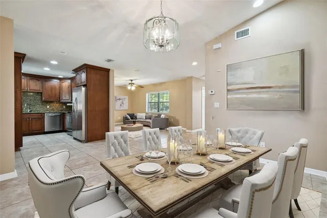 a dining room with furniture a kitchen and chandelier