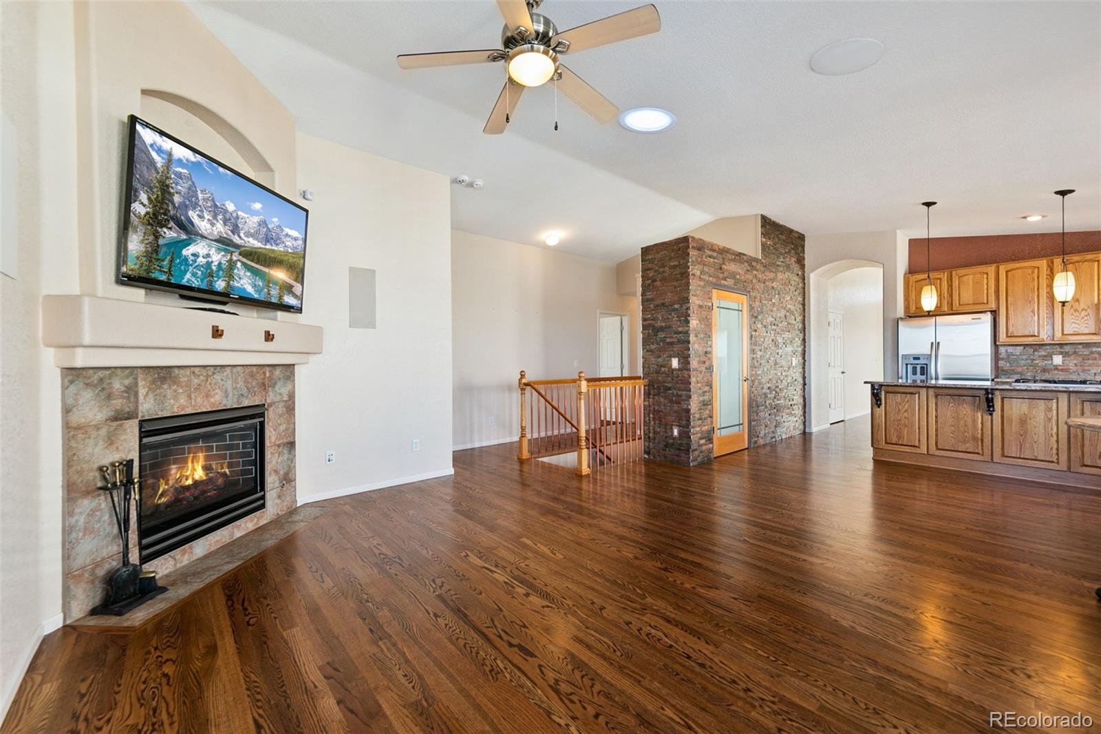 10072 Williams Way Thornton, CO 80229 - Photo 11 of 24 a living room with furniture wooden floor and a fireplace