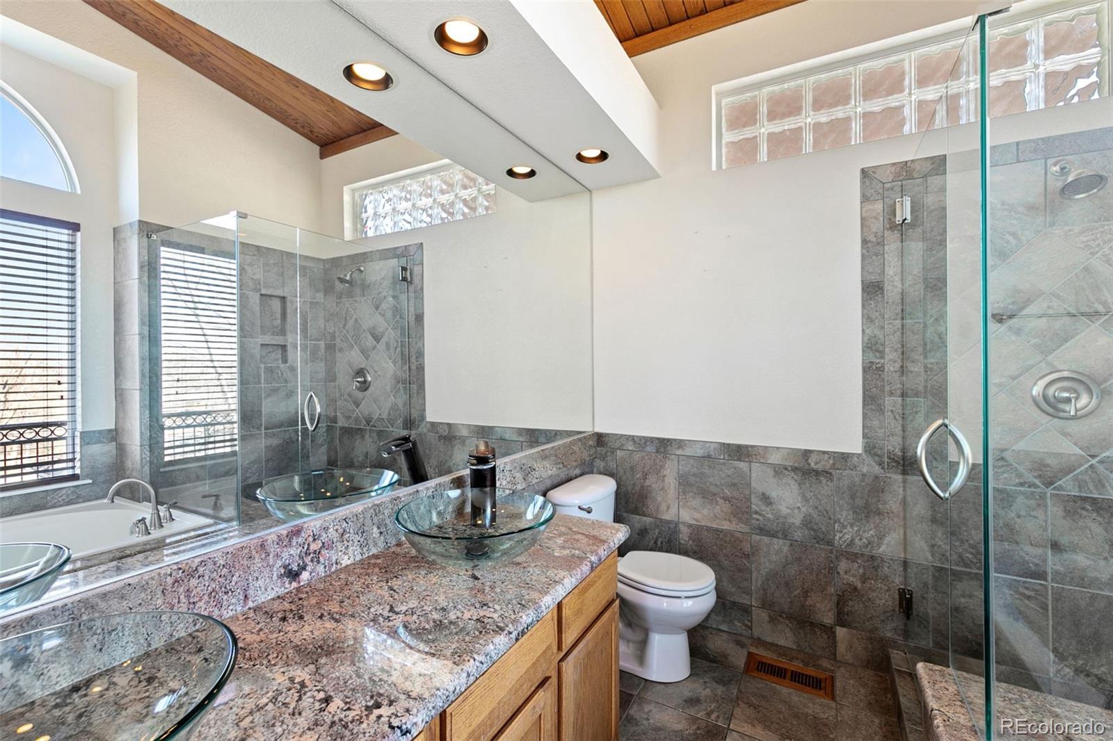 10072 Williams Way Thornton, CO 80229 - Photo 14 of 24 a bathroom with a granite countertop sink toilet and shower