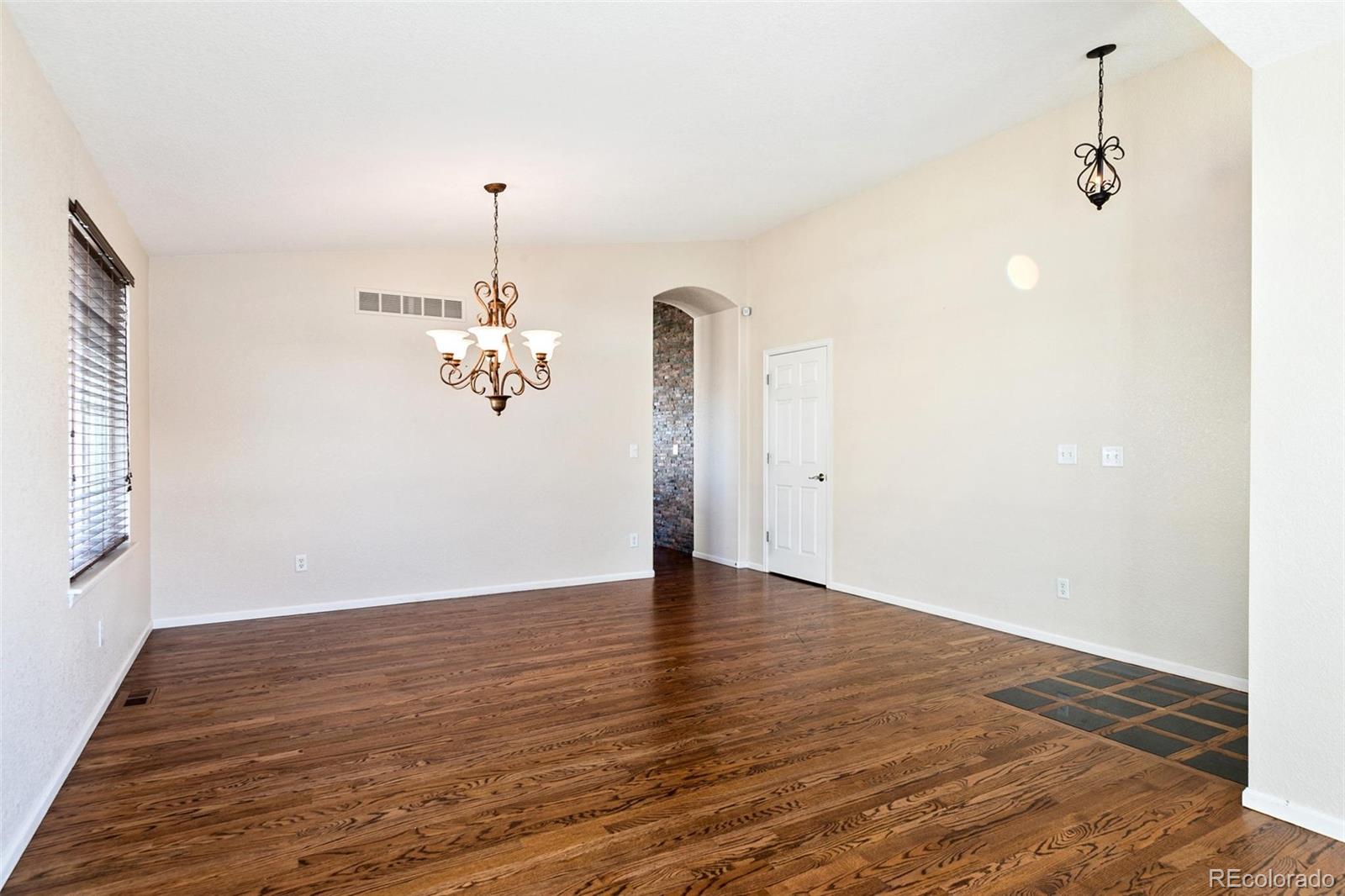 10072 Williams Way Thornton, CO 80229 - Photo 4 of 24 a view of a room with wooden floor chandelier and a window