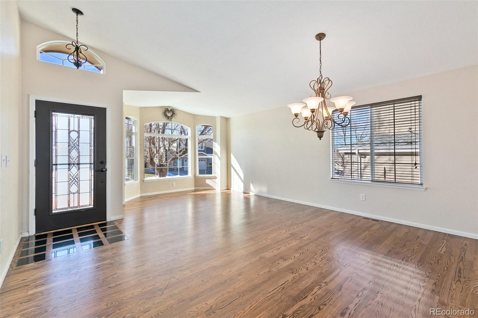 10072 Williams Way Thornton, CO 80229 - Photo 6 of 24 a view of an empty room with wooden floor and a window