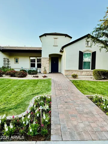 a front view of a house with a garden and yard