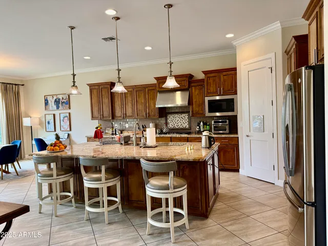 a kitchen with stainless steel appliances granite countertop a sink and a refrigerator