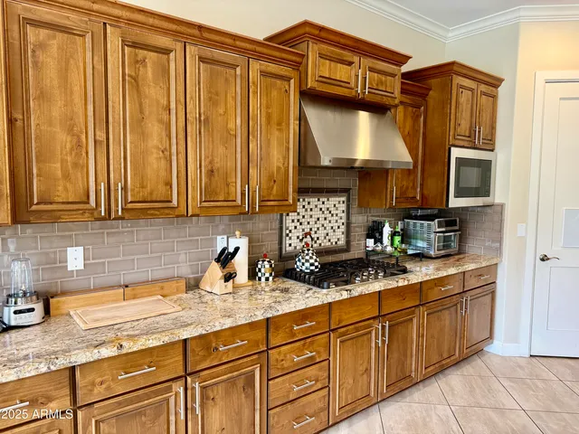 a kitchen with stainless steel appliances granite countertop a sink a stove and cabinets