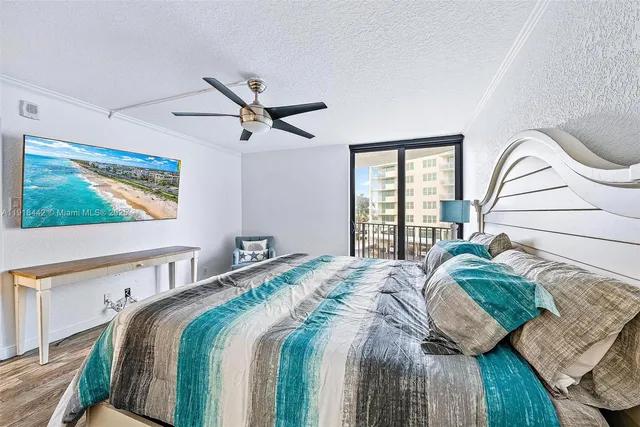 a bedroom with a bed next to a window with a flat screen tv